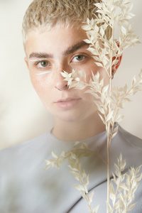 Fashion Portrait einer kurzhaarigen Frau mit Blumen vor dem Gesicht – People Fotograf Hamburg