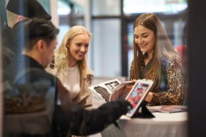 Laechelnde Personen beim Betrachten einer Kunstausstellung in Hamburg – Eventfotograf Hamburg