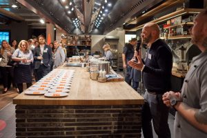 Mann begrueßt Nachwuchsjuristen beim Clavisto Kochevent in Hensslers Kueche Hamburg – Eventfotograf Hamburg