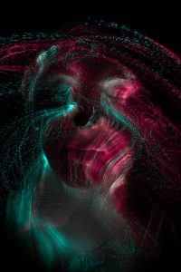 Experimentelles Langzeitportrait mit roten Lichtspuren einer Glasfaserlampe auf dem Gesicht – People Fotograf Hamburg