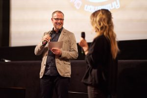 Mann mit Mikrofon auf einer Buehne beim Hamburg Animation Club – Eventfotograf Hamburg