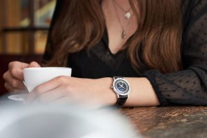 Frau hält eine cafetasse mit ihrer Hentschel Uhr am Handgelenk – Produktfotograf Hamburg