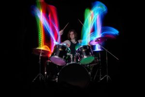 Schlagzeuger trommelt und erzeugt Lichteffekte – Musikfotograf Hamburg