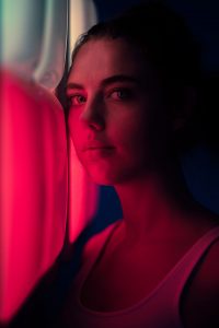 Portrait einer jungen Frau neben pinken Neonlichtern – People Fotograf Hamburg