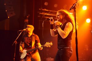 Saenger und Bassist bei einem Liveauftritt – Musikfotograf Hamburg