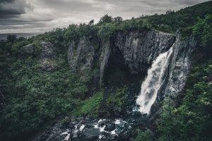 Wasserfall auf Island mit vielen Baeumen und Felsen – Landschaftsfotograf Hamburg