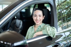 Frau sitz in neuem Auto und laechelt aus dem Fenster – People Fotograf Hamburg