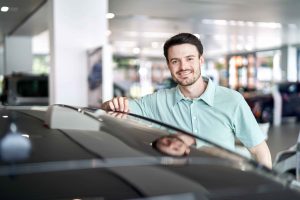 Mann laechelt an seinem neuen Auto – People Fotograf Hamburg