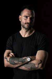 Dunkles Studioportrait von Mann mit Tattoos – People Fotograf Hamburg