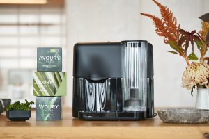 Eine schwarze Teemaschine steht auf einem Holztisch